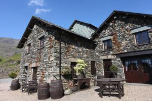 a stone building with barrels in front of it at The Mountain Cottages - Carpenters in Coniston