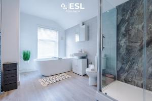 a bathroom with a tub and a toilet and a shower at Stylish 3 Bedroom Townhouse close to Chester City Centre - Ideal for Families, Groups and Contractors in Hough Green +43 photos
