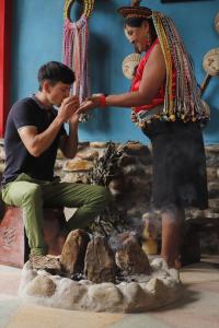 una mujer está ayudando a un hombre sentado en una roca en POSADA KAUAI, en Mocoa