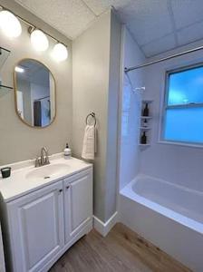 ein Badezimmer mit einem Waschbecken, einer Badewanne und einem Spiegel in der Unterkunft Hudson #1 Private Two Bed near Xavier & Downtown in Cincinnati