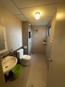La petite salle de bains est pourvue de toilettes et d'un lavabo. dans l'établissement Suria Residence Homestay, à Shah Alam