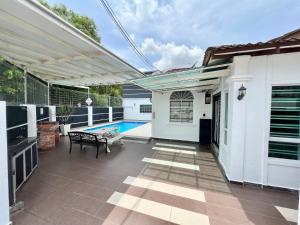 a patio with a pool and a pergola at H&H 1 Guest House in Malacca