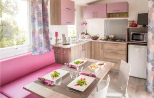 a kitchen with pink cabinets and a table with food at Pet Friendly Stacaravan in Tuoro sul Trasimeno