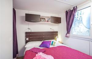 a bedroom with a bed with pink sheets and a window at Pet Friendly Stacaravan in Tuoro sul Trasimeno
