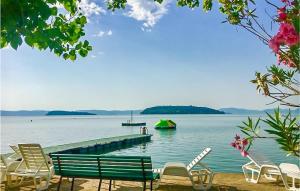 a group of chairs and a dock with a boat in the water at Pet Friendly Stacaravan in Tuoro sul Trasimeno