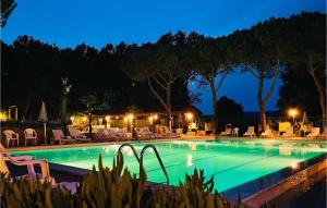 a swimming pool at night with chairs and tables at Pet Friendly Stacaravan in Tuoro sul Trasimeno +10 photos
