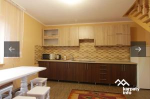 a kitchen with wooden cabinets and a counter top at Dva Opryshka in Yaremche
