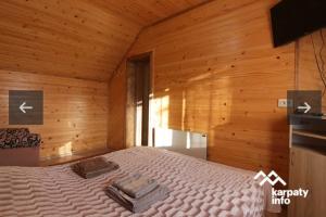 - une chambre avec un lit dans une pièce en bois dans l'établissement Dva Opryshka, à Yaremtche