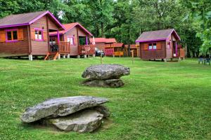 a group of houses with rocks in the grass at Camping municipal de la Lande in Nexon