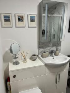 a white bathroom with a sink and a mirror at No5 at 53 - 2 bed apartment in Leek, Staffs Peak District in Leek