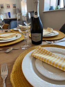 a table with plates and glasses and a bottle of wine at No5 at 53 - 2 bed apartment in Leek, Staffs Peak District in Leek