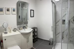 a white bathroom with a sink and a shower at No5 at 53 - 2 bed apartment in Leek, Staffs Peak District in Leek