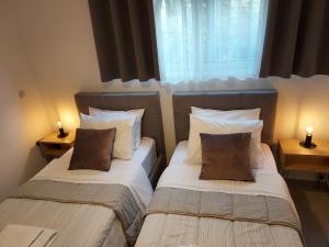 2 Betten in einem kleinen Zimmer mit 2 Lampen in der Unterkunft Apartment near Athens Airport, Rafina Port and Sea in Artemida