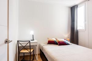 um quarto com uma cama e uma secretária com uma cadeira em Bright Apartment with Balconies em Barcelona