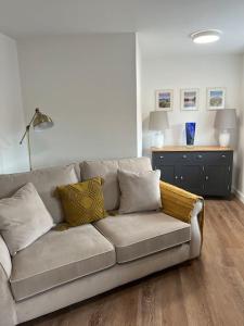 a living room with a couch with pillows on it at No5 at 53 - 2 bed apartment in Leek, Staffs Peak District in Leek