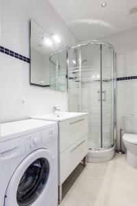 uma casa de banho branca com uma máquina de lavar roupa e um chuveiro em Bright Apartment with Balconies em Barcelona
