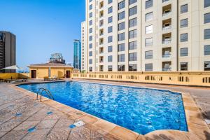 a large swimming pool in front of a building at Lovely 2-bed condo in JBR - 5 mins from beach - Palm View! in Dubai