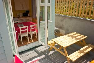 a porch with a wooden table and a kitchen with a table at A02 Mermaids Nest A2, Riviere Towans in Hayle