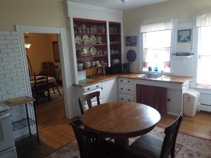 uma cozinha com uma mesa e um lavatório e uma sala de jantar em Terrapin Hostel em Kingfield