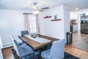 uma cozinha e sala de jantar com uma mesa de madeira e cadeiras em Sunset house near Sunday River Black Montain em Rumford