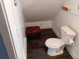 Elle comprend une petite salle de bains pourvue de toilettes et d'un tabouret rouge. dans l'établissement Terrapin Hostel, à Kingfield