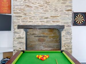 a pool table with balls in front of a fireplace at The Old Vicarage in Polperro