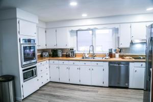 a white kitchen with white cabinets and a sink at Sunset house near Sunday River Black Montain in Rumford