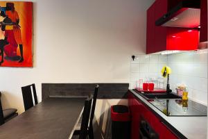 eine Küche mit roten Schränken und einer Arbeitsplatte in der Unterkunft Stopover in Vizille #EL in Vizille
