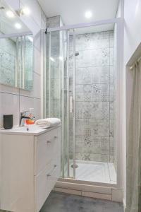 Un baño blanco con ducha y lavabo. en Le Bossuet en plein coeur du centre historique, en Dijon