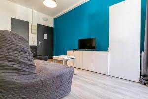 Una sala de estar con un sofá y una pared azul. en Le Bossuet en plein coeur du centre historique, en Dijon