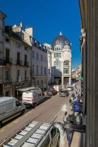 Una vista de una calle de la ciudad con coches y edificios. en Le Bossuet en plein coeur du centre historique, en Dijon