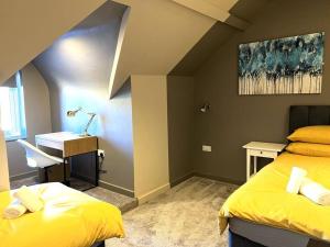 a bedroom with two beds and a desk and a sink at University Duplex • Sleeps 6 in Loughborough