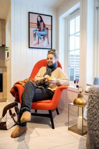 a man sitting in a chair playing a video game at Vollsnes Feriehus in Hjelle