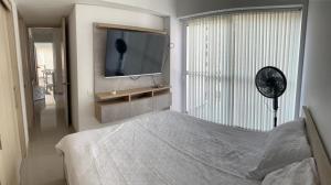 1 dormitorio con 1 cama y TV en la pared en Apartamentos Amoblados, en Cali