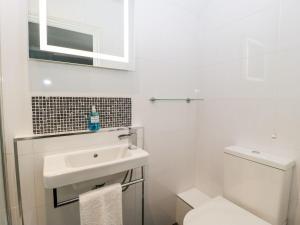 a white bathroom with a sink and a toilet at Tree of Life House, Number 27 Bere Lane in Glastonbury +32 photos