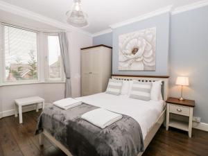 a white bedroom with a large bed with white pillows at Tree of Life House, Number 27 Bere Lane in Glastonbury