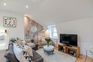 een woonkamer met een bank en een tv bij Penthouse Kings Cross in Londen