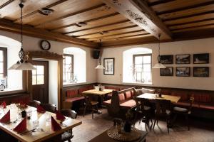 un restaurant avec des plafonds en bois, des tables et des chaises dans l'établissement Der Thomataler Wirt, à Thomatal