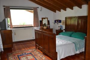 ein Schlafzimmer mit einem Bett und einem großen Fenster in der Unterkunft Casa di Montagna San Colombano in San Colombano