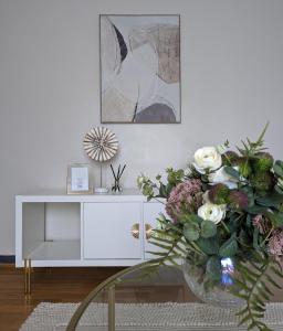 a white cabinet with a vase of flowers on a table at 1BD apartment with balcony in Hoxton - Zone 1 in London