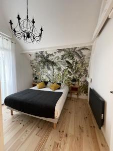 a bedroom with a large bed and a chandelier at La Roseraie in Saint-Étienne-au-Mont