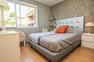 a bedroom with a bed with an orange pillow on it at CABO Palos 4 2 2 ONLY FAMILIES in Salou