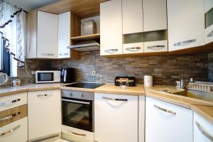 a kitchen with white cabinets and a sink at Apartment Vanessa in Gospić