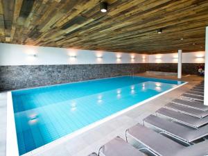 a large swimming pool with chairs around it at Landal Chalet Matin in Bürserberg