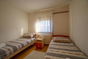 two beds in a room with a window at Apartment Vanessa in Gospić