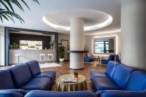 佛羅倫斯的住宿－幻影酒店，客厅设有蓝色的沙发和柱子