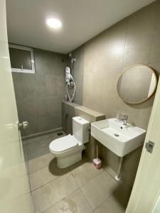 a bathroom with a toilet and a sink and a mirror at Homestay Sandakan CLL in Sandakan