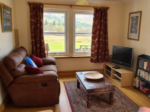 a living room with a couch and a tv at Watercolour in Ardgour
