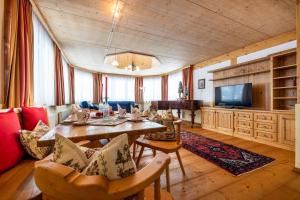 ein Wohnzimmer mit einem Tisch und einem TV in der Unterkunft Hotel Breitlehenalm in Obertauern