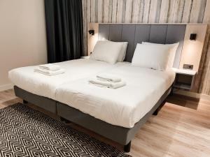 a bedroom with a large bed with two towels on it at NEW! Fantastic appartments - Duno Lodges 4 persons in Oostkapelle